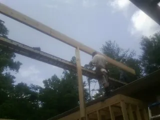 Carpenter setting a ridge beam over a new addition frame — Ice Dam Removal by Roofing Brothers in Hayward