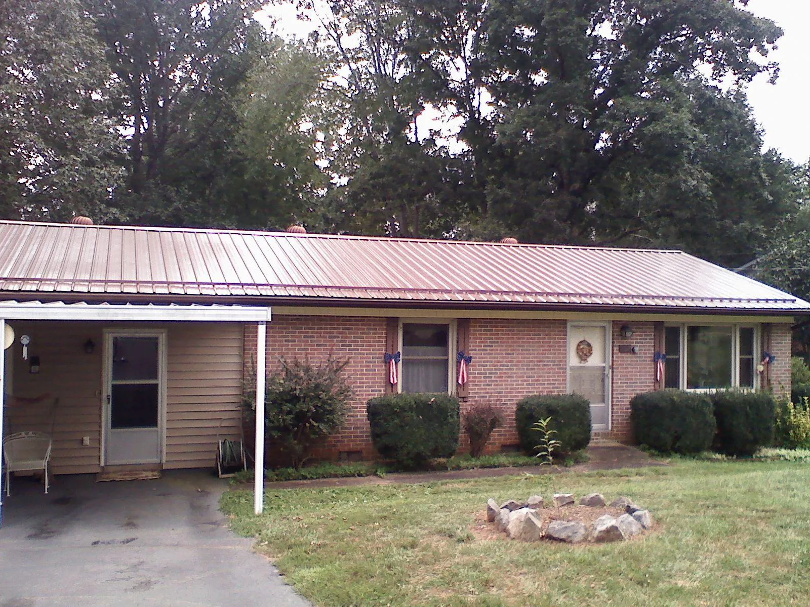 Bronze metal roof and carport on a brick ranch home — Roof Repair work by our crew in Hayward